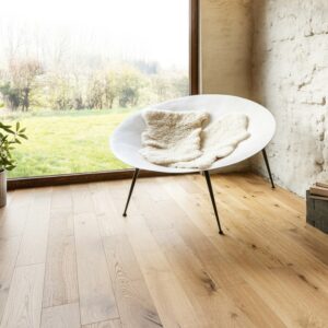 Parquet contrecollé vernis en chêne noueux avec un ton miel et des lames fines.